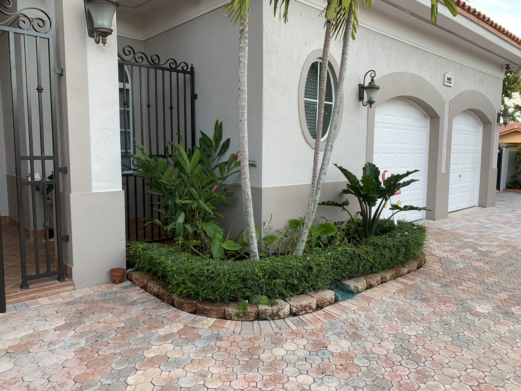 Arched garage entry with hedge and planting